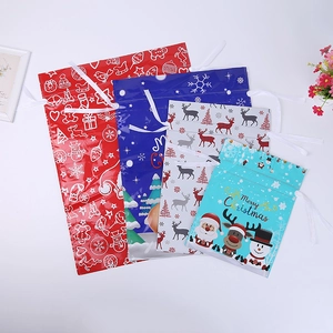 Detail of assorted Christmas drawstring gift bags with festive Santa and reindeer patterns