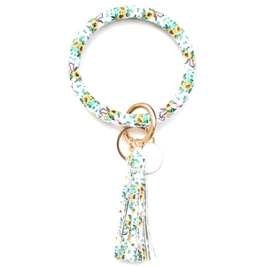 Detailed view of sunflower print PU leather circle bracelet keychain with tassel and gold ring