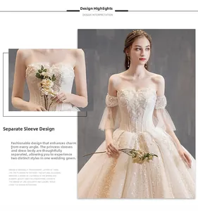 Detail showing the detachable puff sleeve design and lace embroidery on the ivory bridal gown