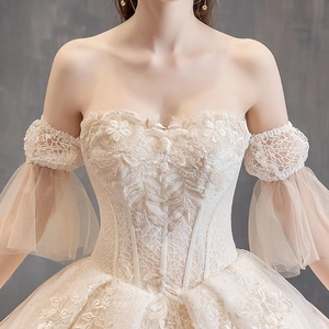 Elegant champagne off-shoulder wedding gown with lace floral embroidery and beadwork