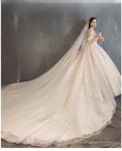 Detail of sequined off-shoulder wedding gown featuring a luxury long cathedral train