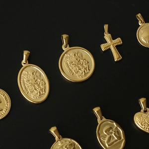 Detailed view of assorted 18K gold plated titanium steel religious pendants