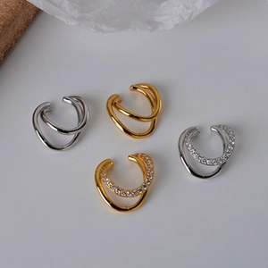 Detail of silver and gold ear cuffs set featuring simple bands and cubic zirconia accents
