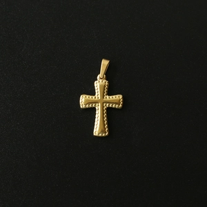 Close-up of 18K gold-plated titanium steel cross pendant with embossed texture on black background