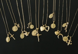 Collection of vintage gold-plated titanium steel pendants with coin and cross designs