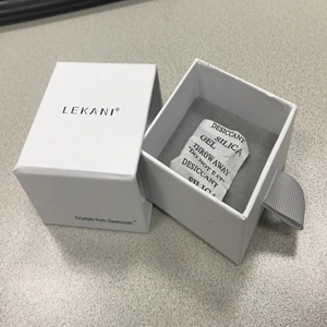 Detail view of white drawer-style jewelry box with grey velvet lining and brand logo