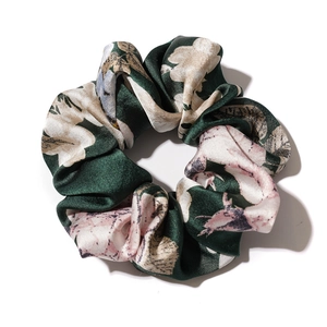 Deep green satin scrunchie with pink floral prints on a clean white background