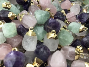 Detailed pile of natural raw stone pendants with gold metal edging in various colors