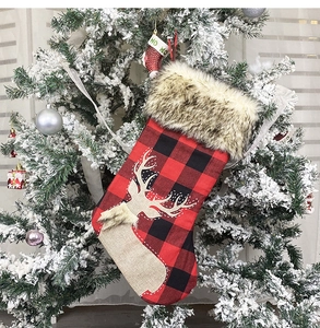 Close-up of red and black buffalo plaid Christmas stocking with fur trim and elk pattern
