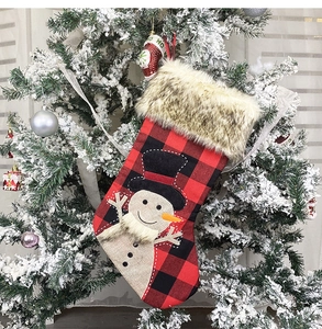 Close-up of a buffalo plaid Christmas stocking with white faux fur and 3D snowman mascot