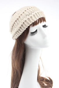 Detailed close-up of beige chunky knit headband with thick diamond pattern texture