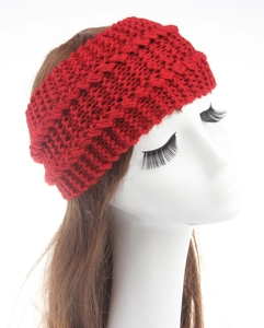 Close-up of red chunky cable knit winter headband with detailed braided texture