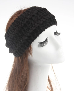 Detailed view of black cable-knit winter headband with thick textured crochet pattern