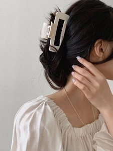 Detail of matte cream square hair claw clip worn by a model in a minimalist Korean style