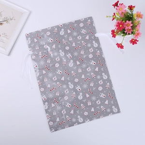 Flat lay of gray Christmas drawstring gift bag with snowman and reindeer patterns