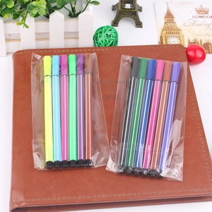 Detail of 12-color hexagonal watercolor markers with classic stripe pattern on a notebook
