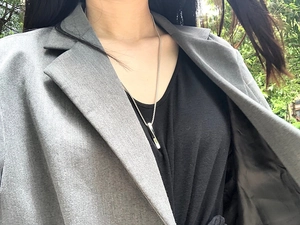 Outdoor model wearing a twisted bar pendant necklace in silver titanium steel