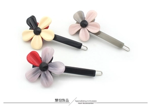 Vue détaillée de trois barrettes à fleurs en acétate avec pierres noires centrales