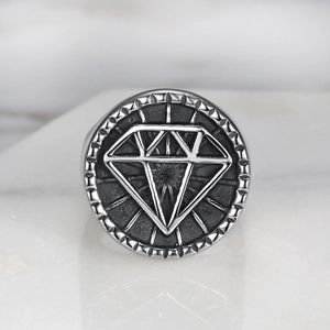Detailed macro of vintage punk steel ring with engraved geometric diamond logo and silver band
