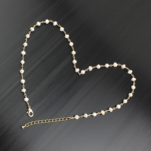 Macro detail of natural freshwater pearl necklace with gold-plated lobster clasp and chain