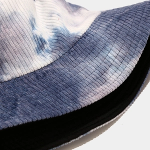 Close-up of blue and white tie-dye corduroy fabric texture on a bucket hat brim