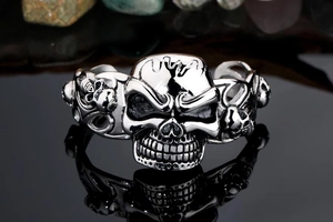 Macro detail of gothic skull bangle in polished steel finish with sharp reflections