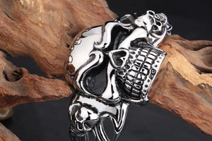 Close-up of vintage punk style silver skull bracelet displayed on rustic wood