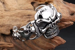 Detailed macro view of punk skull carvings and woven texture on a steel bangle