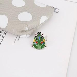 Close-up of a colorful enamel frog brooch on a white background with 45-degree angle detail