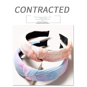 Detail of cross-knot striped headbands in warm orange and cool blue-purple knit fabric