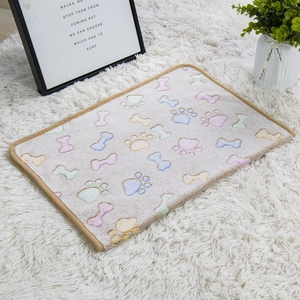 Detail of soft beige flannel pet blanket with colorful paw prints and bone patterns