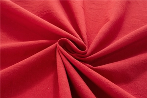 Macro detail of red washed cotton fabric texture and natural fiber weave on table cloth