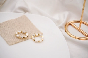 Detailed view of baroque freshwater pearl elastic rings on natural linen background