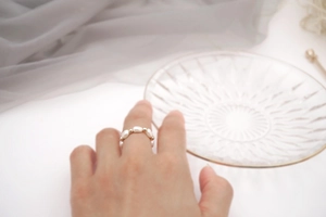 Close-up of handmade baroque freshwater pearl ring with gold beads on silk fabric