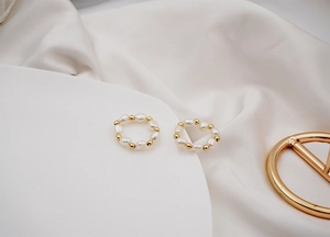 Macro shot of baroque freshwater pearls and gold beads on an elastic ring band