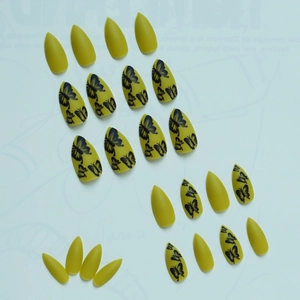 Almond-shaped matte mustard yellow press-on nails featuring detailed black butterfly art
