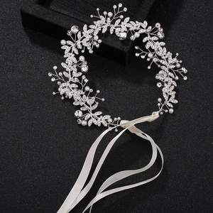 Detail of silver bridal leaf headband with marquise rhinestones and white pearls on ribbons