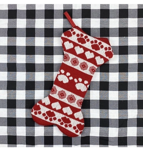 Detailed knit texture of bone-shaped Christmas stocking with heart and paw patterns