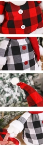 Macro view of Christmas plush snowman featuring red and black plaid fabric and button details