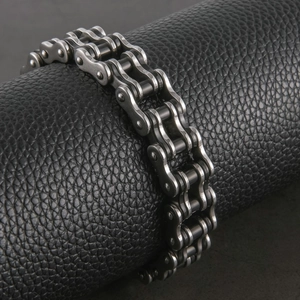 Vista macro del bracciale a catena da moto in acciaio al titanio argento su pelle nera