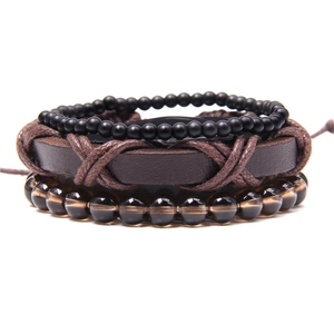 Close-up of bohemian layered bracelet set with natural stone beads and leather strap