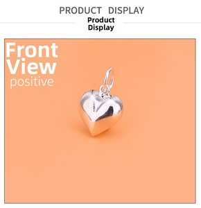Polished silver heart pendant with ring connector shown on orange background
