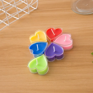 Dettaglio di candele profumate a forma di cuore in vari colori su legno