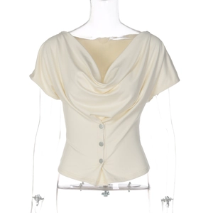 Detail of cream cowl neck top showing elegant draped neckline and three buttons on the waist