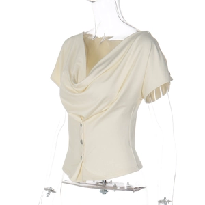 Detail of cowl neck cream short sleeve top with three metal buttons and silky texture