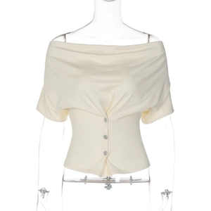 Detail of off-white off-shoulder top featuring draped neckline and three decorative buttons