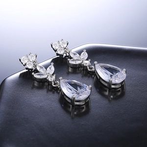 Detailed close-up of teardrop zirconia earrings with silver plating and floral accents