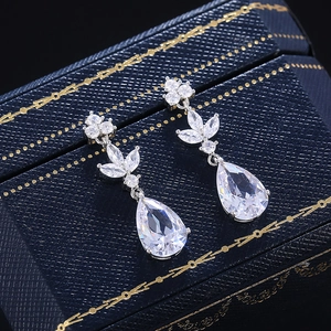 Detailed view of silver pear-shaped zircon earrings on a premium blue jewelry box