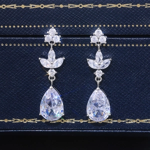 Macro shot of silver teardrop earrings with cubic zirconia on navy jewelry box