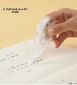 Close-up of 5mm wide correction tape being used on grid paper by a hand model